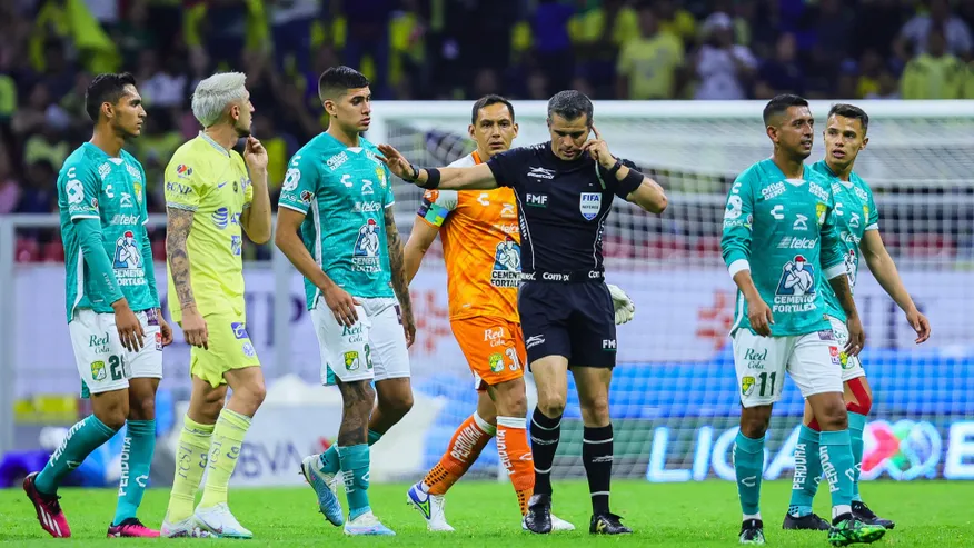 Referee Fernando Hernández communicating with VAR officials over the microphone