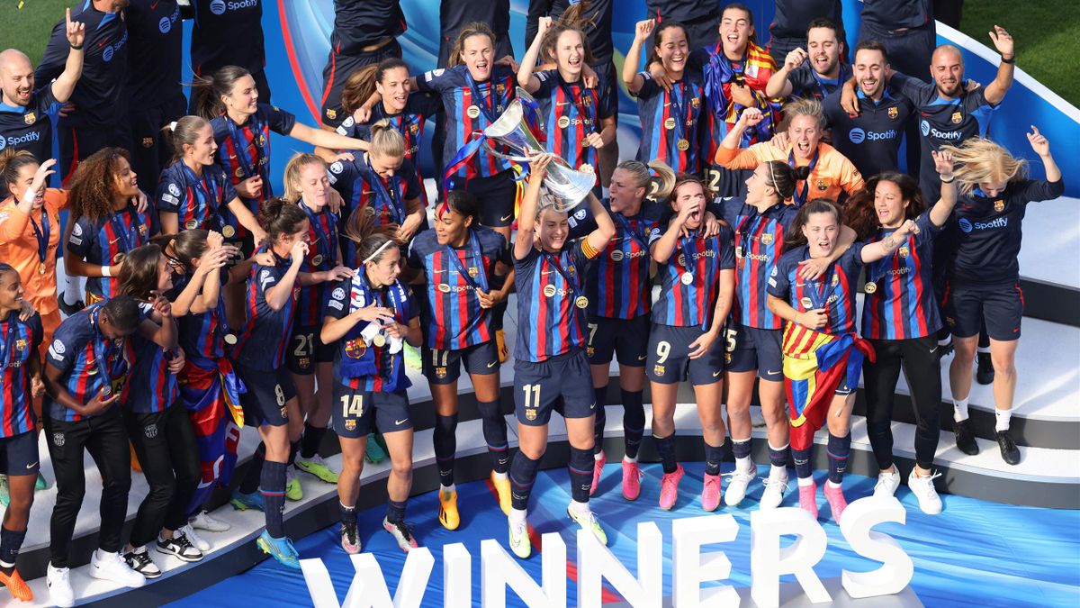 Barcelona players celebrate with the UEFA Women's Champions League trophy on the podium after beating Wolfsburg 3-2 in the final at the Philips Stadium in Eindhoven on June 3, 2023.