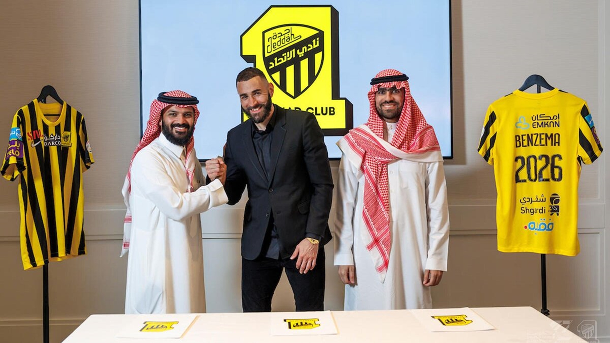 Karim Benzema poses with official of Al-Ittihad after completing his transfer to the club