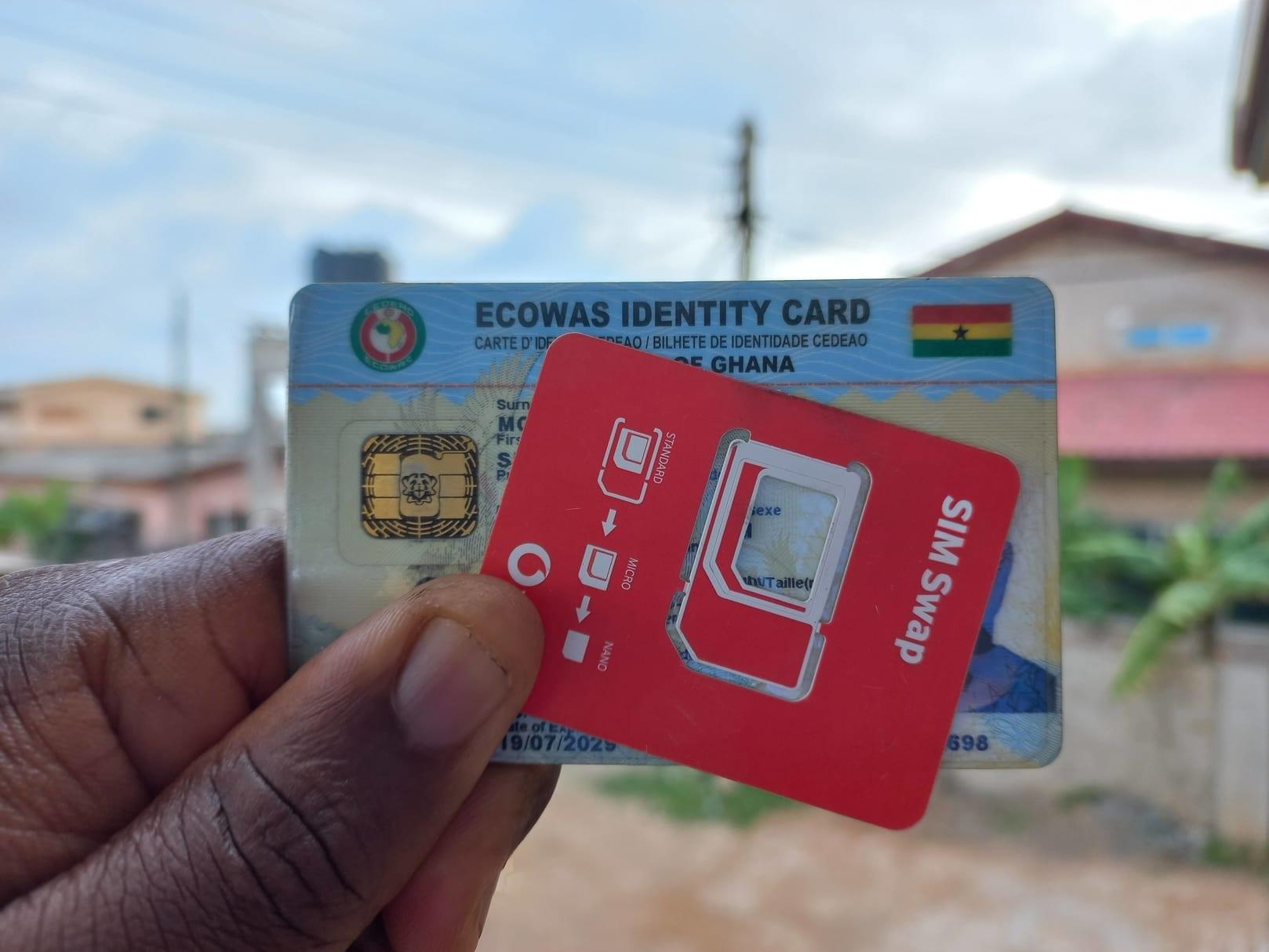 Person holding a SIM card pack and the Ghana Card. All SIM Cards must be re-registered with the Ghana Card.