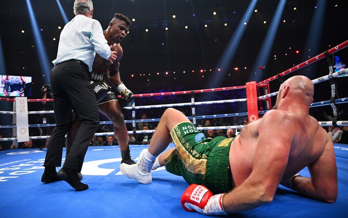 Francis Ngannou blocked by the referee while Tyson Fury lay on the canvas following a knockdown during the Fury vs Ngannou boxing match at the Kindom Arena in Saudi Arabia