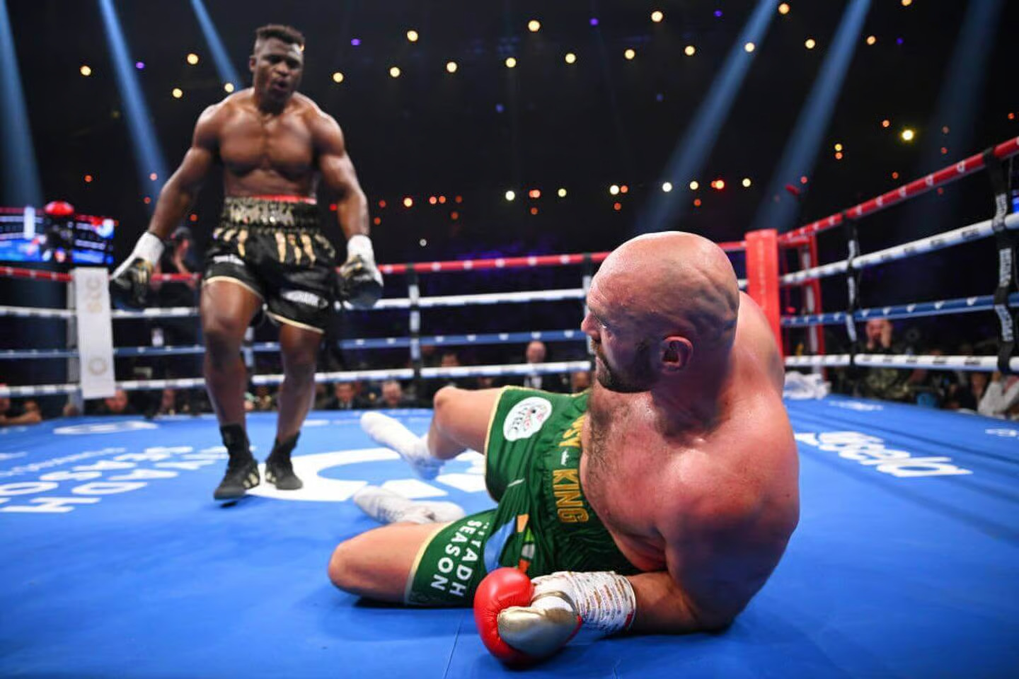 Francis Ngannou standing over Tyson Fury after knocking him down in round 3 of their 10 round fight in Saudi Arabia