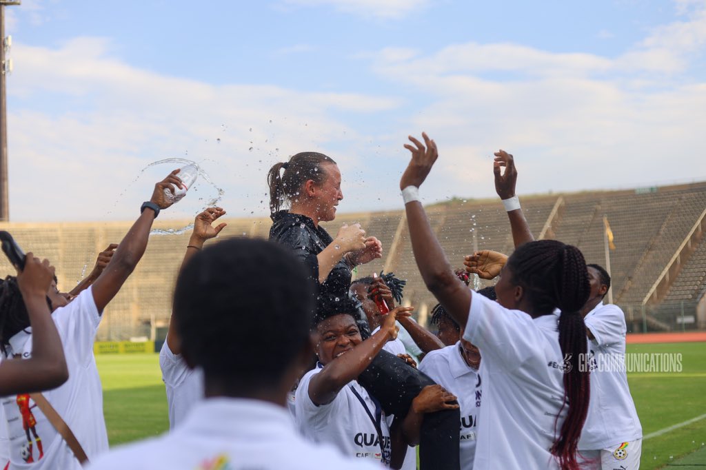 Black Queens celebrate their qualification to AWCON 2024 by carrying their coach Hauptle