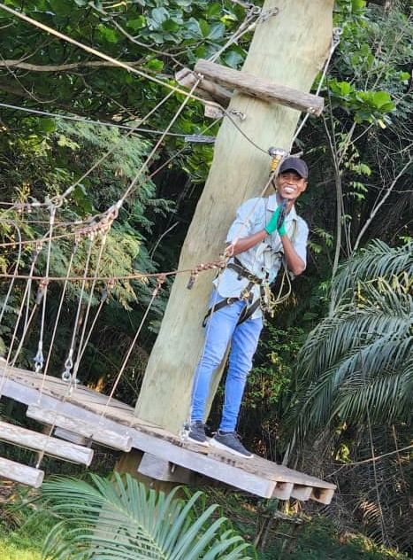 A participant celebrates completing some obstacles during the High Ropes Course at the Legon Botanical Gardens