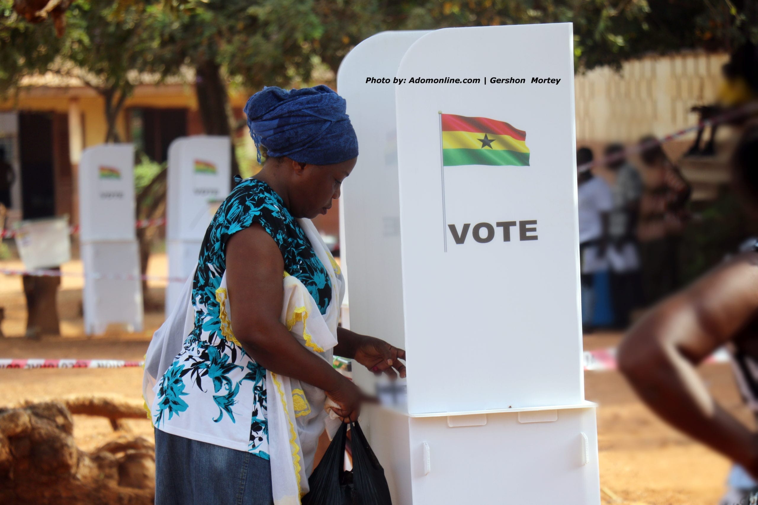 A woman casting her vote at a voting booth during elections in Ghana