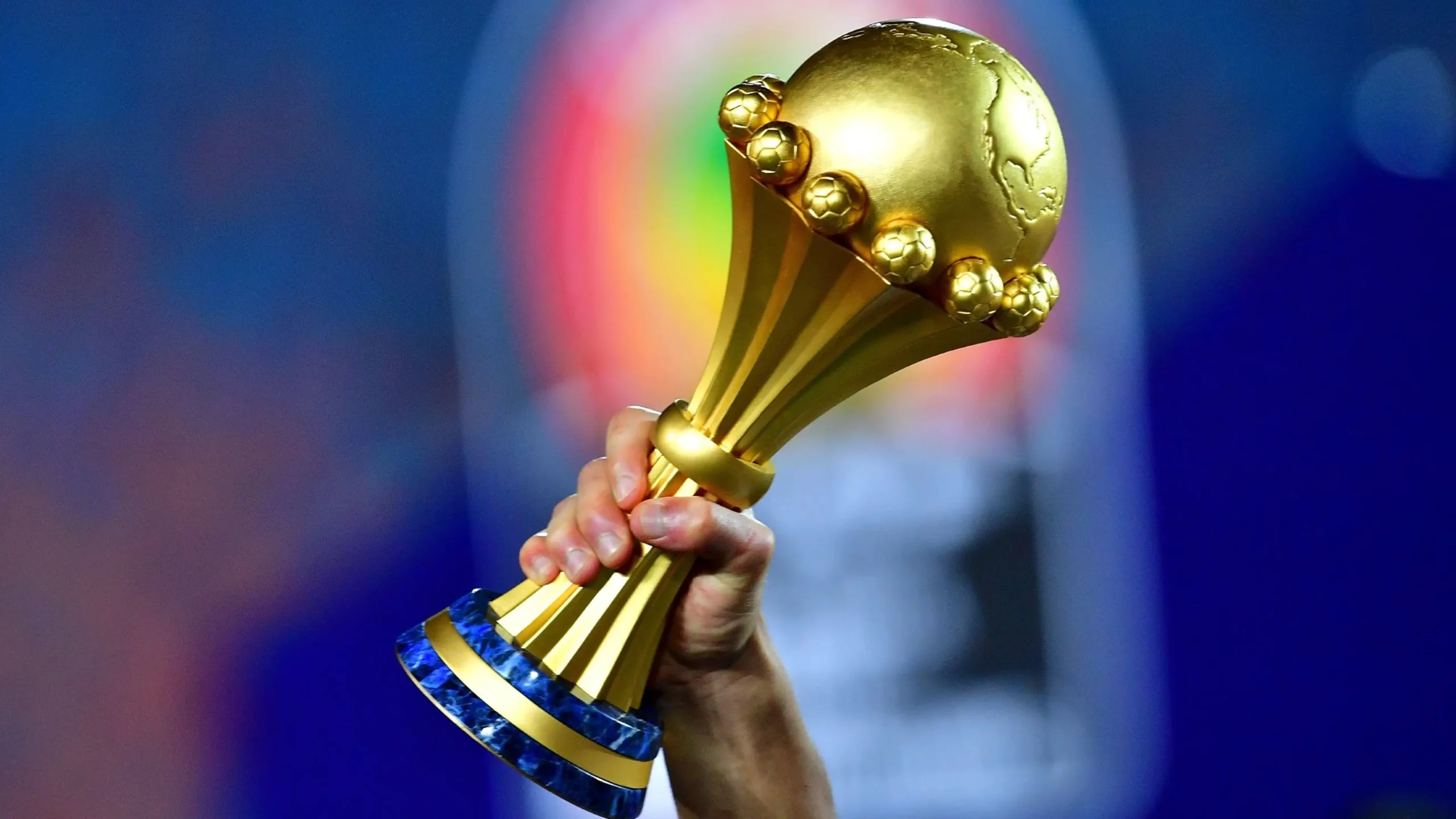 A hand holding the AFCON trophy. AFCON 2023 will not be on DSTV